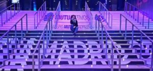 Carolina Gómez de Virtualia sentada en las escaleras iluminadas de la Caja Mágica